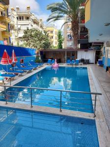 a large swimming pool with chairs and a pink float at Larsens Suit Hotel in Alanya