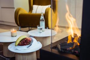 un tavolo con un cesto di frutta e una bottiglia di vino di Passau - Suites a Passavia