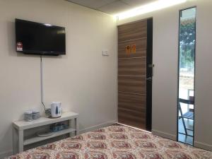 a room with a door and a television on the wall at Laman Cottage @ Brisu, Melaka in Melaka +11 photos