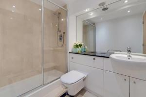 a bathroom with a toilet and a sink and a shower at Excel London City Airport Seagull Lane Royal Victoria 2 Bedrooms Apartments in London