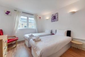 1 dormitorio con 2 camas y ventana en Excel London City Airport Seagull Lane Royal Victoria 2 Bedrooms Apartments, en Londres