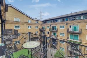 a balcony with a table and chairs and a building at Excel London City Airport Seagull Lane Royal Victoria 2 Bedrooms Apartments in London