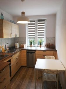 a kitchen with wooden cabinets and a white table at Apartament śródmiejski in Gdańsk