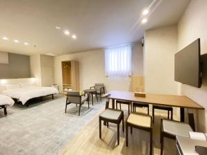 広島市にあるたかのばしホテルのベッドとテーブルと椅子のある部屋