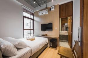 um pequeno quarto com uma cama e uma televisão em U chaikhong em Chiang Khan