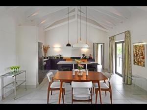 a kitchen and dining room with a wooden table and chairs at Small Wonder in Franschhoek