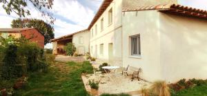 a table and chairs in a yard next to a building at Les Hauts de Grazac in Grazac