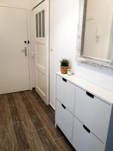 a bathroom with a white dresser and a mirror at Apartament śródmiejski in Gdańsk