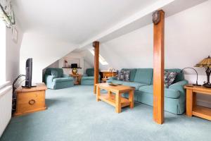 un soggiorno con 2 divani blu e una TV di The Nest- Cosy Holiday Cottage a Errol