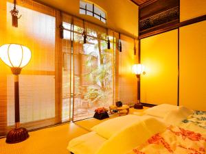a bedroom with yellow walls and a bed and a window at Udatsuya in Osaka