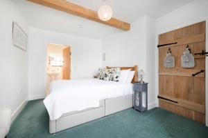 una camera con un letto bianco e un tappeto verde di The Nest- Cosy Holiday Cottage a Errol