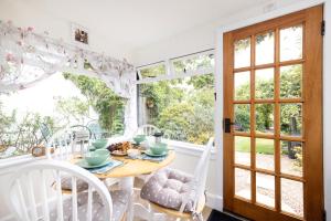 una sala da pranzo con tavolo, sedie e finestra di The Nest- Cosy Holiday Cottage a Errol