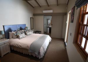 Un dormitorio con una cama grande con almohadas. en Cabriere Cottage, en Franschhoek