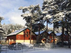ジビジノにあるPelikan Resort Dźwirzyno - Domki przy plażyの柵の前の雪に覆われた家
