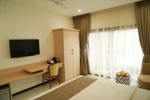 Una habitación de hotel con un escritorio y un televisor. en Arawali Ananta Elite, Ranakpur, en Sādri