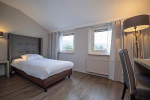 - une chambre avec un lit et 2 fenêtres dans l'établissement Fletcher Zuiderduin Beachhotel, à Westkapelle