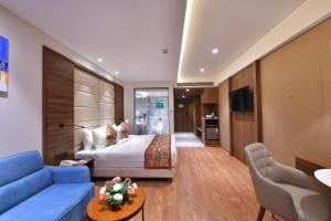 een hotelkamer met een bed en een blauwe bank bij Regenta Fairlark Vadodara in Vadodara