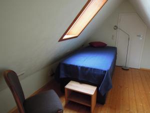 a bedroom with a blue bed and a chair at Ferienwohnung Rose in Preußisch Oldendorf