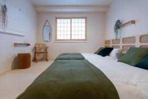 東京的住宿－Asakusa Designer Hotel YOSHII，一间卧室设有两张床和窗户。