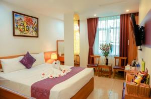 pokój hotelowy z łóżkiem i telewizorem w obiekcie Aloha Hotel w mieście Hanoi