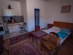 mały pokój z łóżkiem, stołem i krzesłami w obiekcie Mákvirág Apartmanok w mieście Zebegény