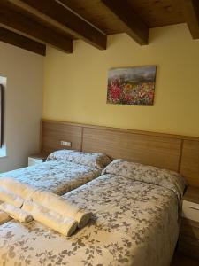 a bedroom with two beds and a painting on the wall at VILLA BERENGUELA in Boca de Huérgano