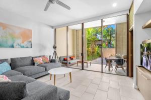 a living room with a couch and a table at Elysium Triton by the Sea in Palm Cove