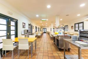 restauracja ze stołami i krzesłami oraz kawiarnią w obiekcie Albergue Inturjoven Punta Umbría w mieście Punta Umbría