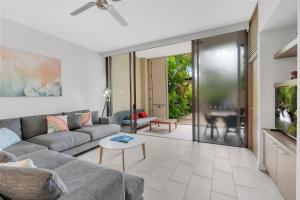 a living room with a couch and a table at Elysium Triton by the Sea in Palm Cove