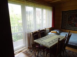 a dining room with a table and a bed and a window at Agawa in Zakopane