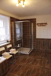 uma casa de banho com duche e cadeiras num quarto em Fuchsbau Leipzig-Schkeuditz em Schkeuditz