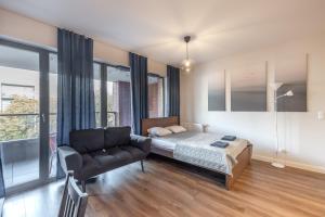 a bedroom with a bed and a chair in it at Apartament z balkonem blisko Starego Miasta in Gdańsk