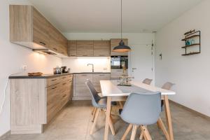 a kitchen with a table and chairs in a room at Whaaw Westende-bad in Middelkerke