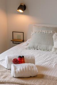 Una cama blanca con toallas y velas. en Whaaw Westende-bad, en Middelkerke