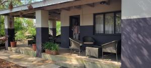 une femme debout à l'entrée d'une maison dans l'établissement Livivane Guest House, à Simunye