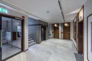 an empty hallway of a building with glass doors at Apartament z balkonem blisko Starego Miasta in Gdańsk