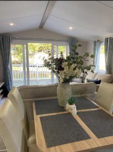 a living room with a vase of flowers on a table at KellysHolidayHomes 26 Willerby 2 bedrooms caravan in Weeley