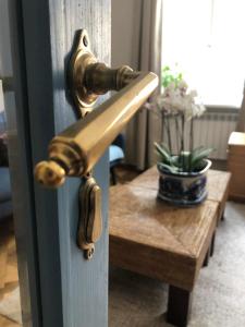 a brass door handle on a door with a table at Przemysl Old Town Style in Przemyśl