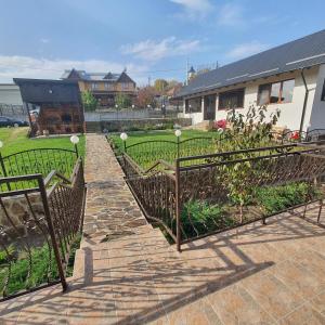 einen Garten mit schmiedeeisernen Zäunen und einem Hof in der Unterkunft Casa Sofia in Bălţăteşti