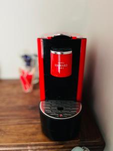 a red and black coffee maker sitting on a table at Hôtel La Villa d'Eze in Éze
