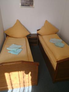 two twin beds in a room with towels on them at Noclegi Hexe in Żegocina