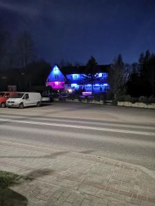 a house with blue and purple lights on it at Noclegi Hexe in Żegocina