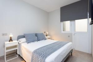 a white bedroom with a bed and a window at Home2Book Cozy Apartment Santa Cruz Skyline in Santa Cruz de Tenerife