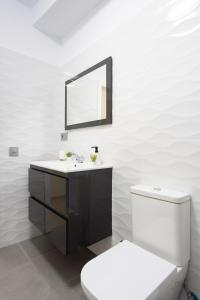 a bathroom with a sink and a toilet and a mirror at Home2Book Cozy Apartment Santa Cruz Skyline in Santa Cruz de Tenerife