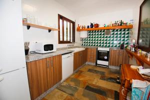 uma cozinha com armários de madeira e um micro-ondas branco em Senia Tomaset I em Onil
