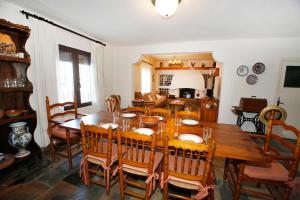 uma sala de jantar com uma mesa de madeira e cadeiras em Senia Tomaset I em Onil