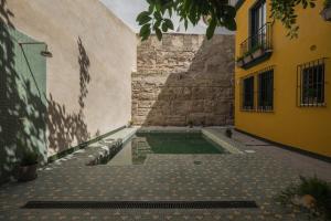an alley with a pool of water between two buildings at Wello Apartments Sevilla in Seville