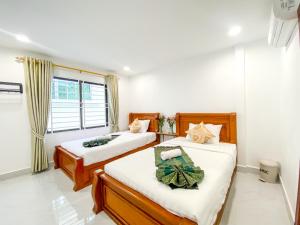 a bedroom with two beds and a window at Nangkol Village in Phnom Penh