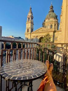 ブダペストにあるHeart of Budapest Luxury Apartment with Amazing Viewの建物前のテーブルに座る者