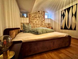 a bed in a room with a stone wall at RÖSCH Apartment in Weimar